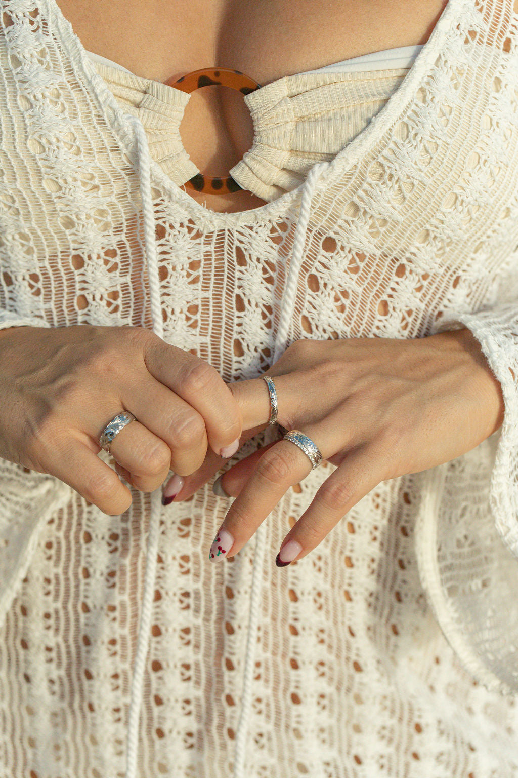 Woman in a knit dress wearing slim gold Hawaiian hand engraved rings