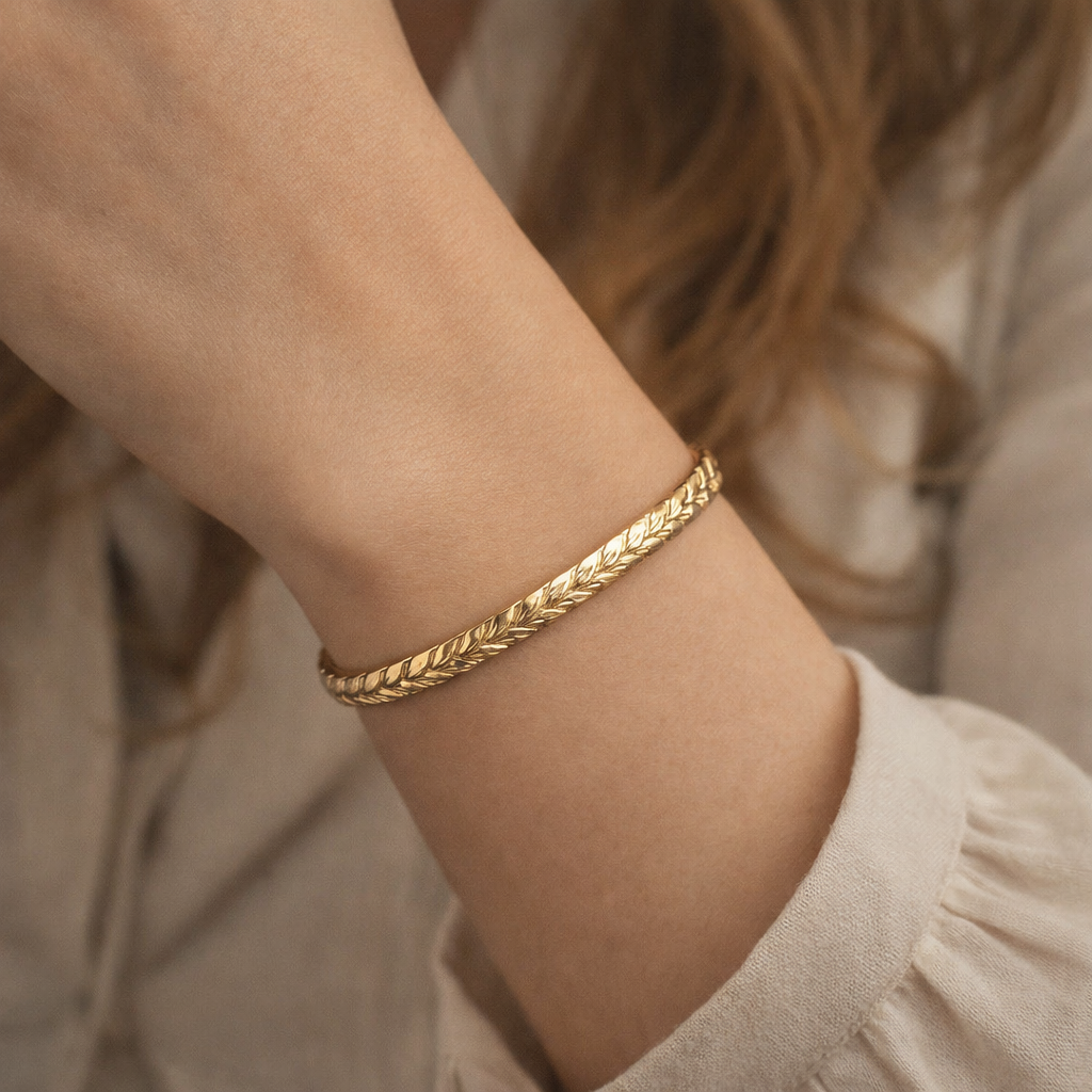 Woman's wrist wearing a solid gold 6mm Hawaiian maile heirloom bangle
