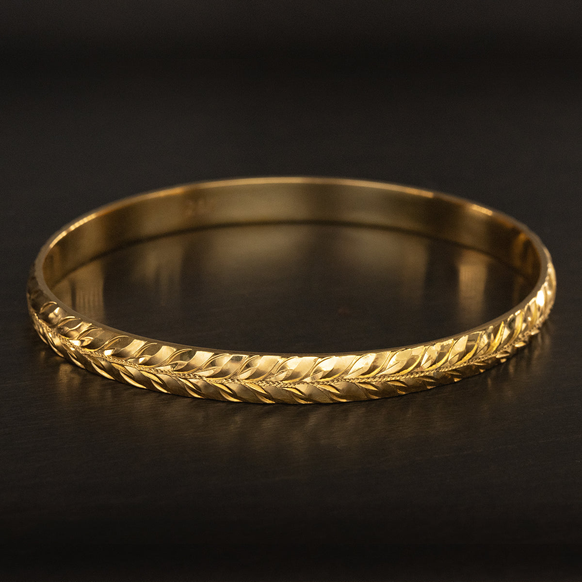 Solid gold 6mm heavy Hawaiian heirloom bangle hand engraved with a maile leaf design