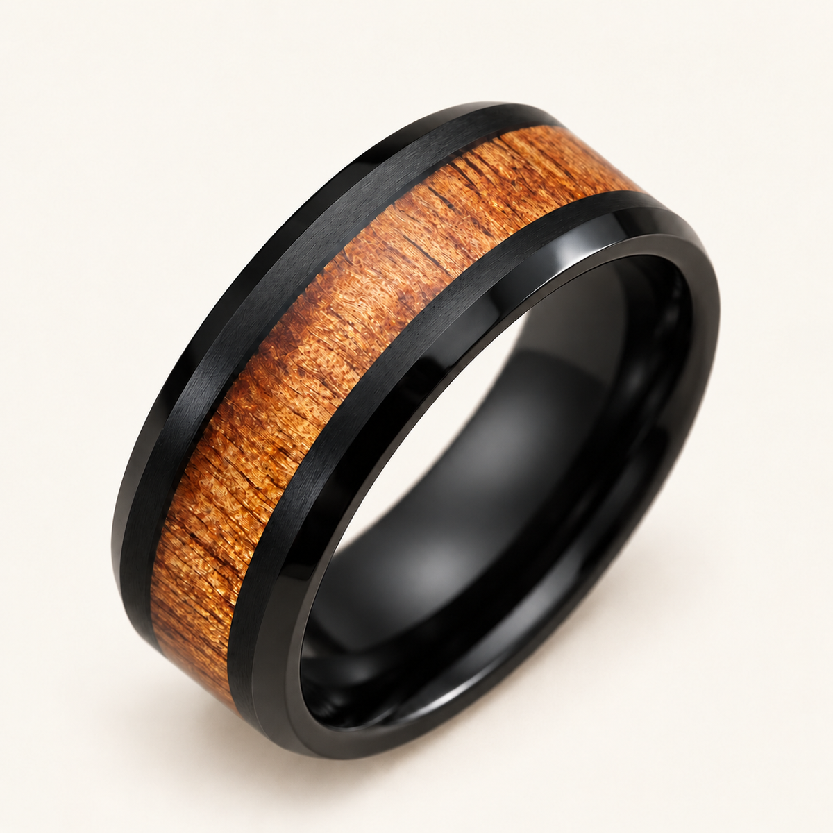 Alternate angled view of a black tungsten ring with satin rails, polished beveled edges and golden koa wood inlay