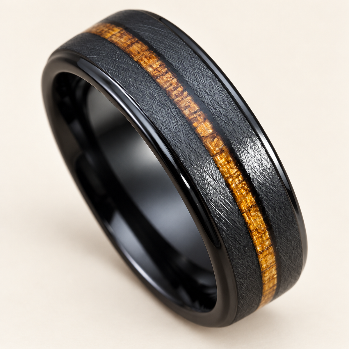 Opposite angle of a black tungsten ring with narrow koa wood inlay and cross-brushed shoulders on ivory
