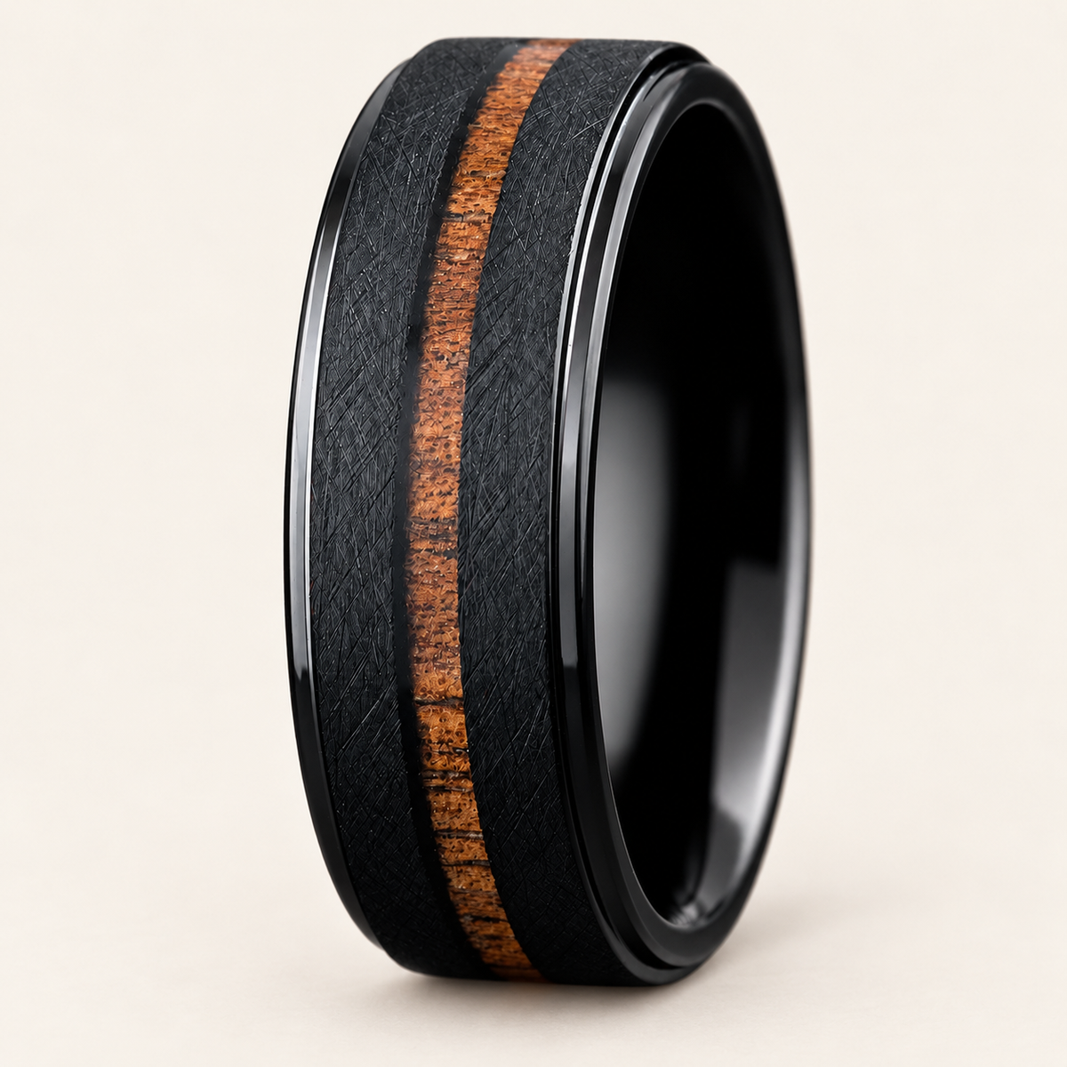 Upright black tungsten ring with cross-brushed shoulders, a narrow Hawaiian koa wood stripe and polished stepped edges on ivory