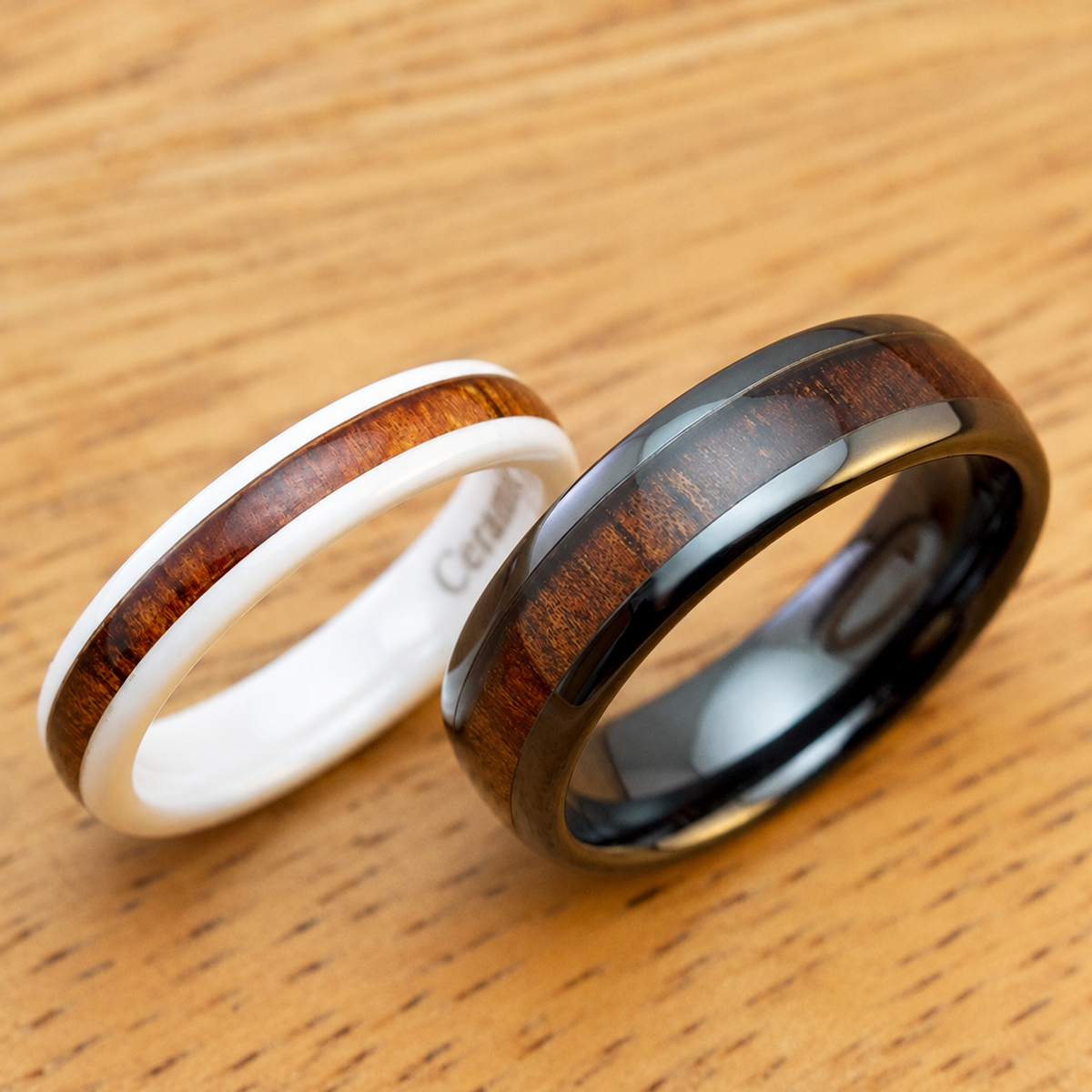 Pair of black and white ceramic rings with Hawaiian koa wood inlays