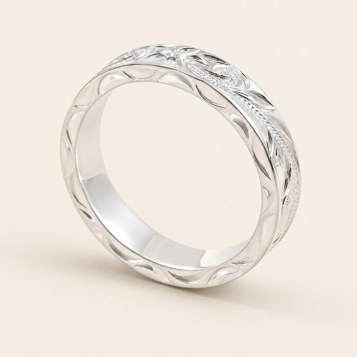 Sterling silver 4mm Hawaiian heritage ring with engraved side faces, upright view on ivory