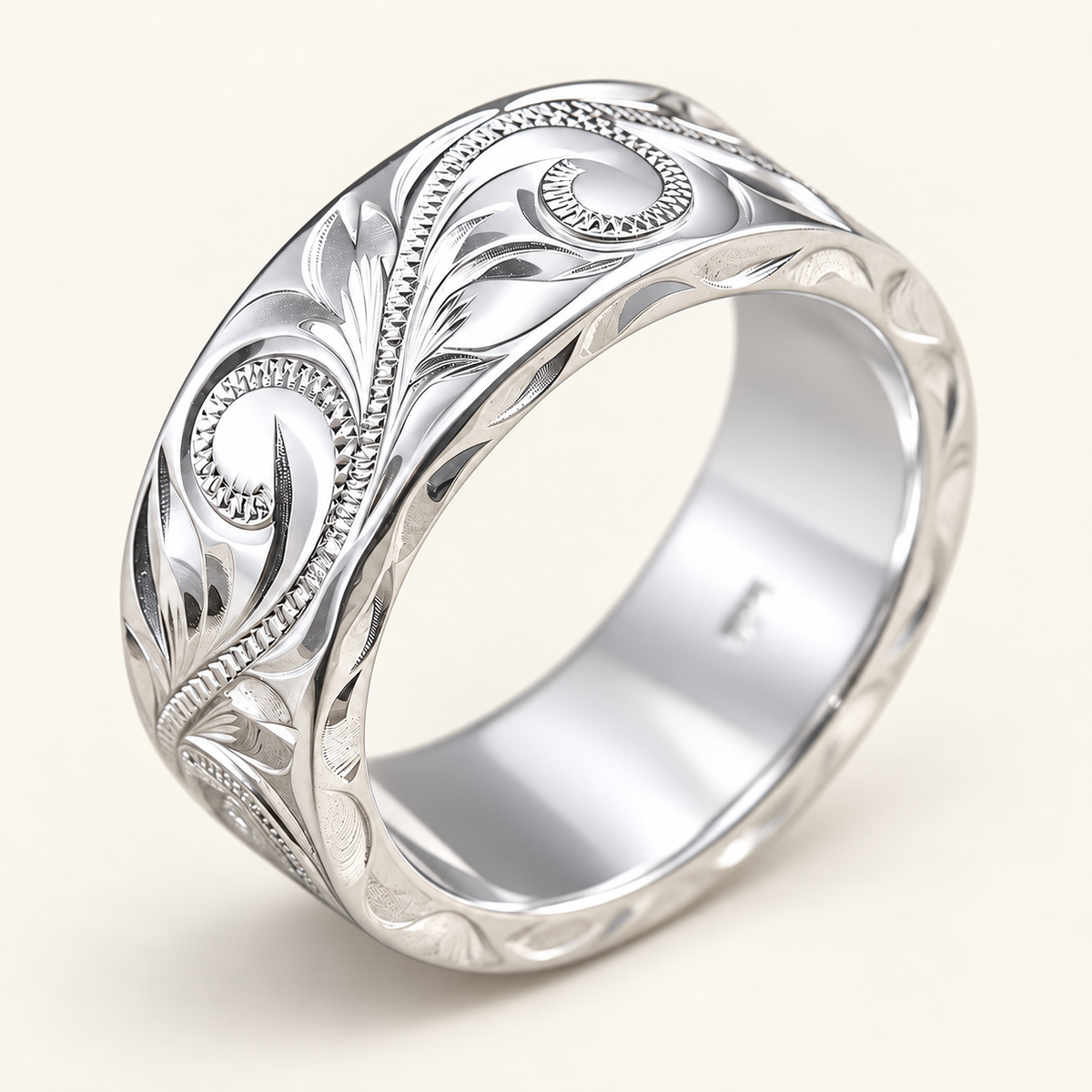 Heavy 8x2mm sterling silver Hawaiian hand-engraved flat ring, open three-quarter view showing scrolls, leaves and engraved edges on ivory.