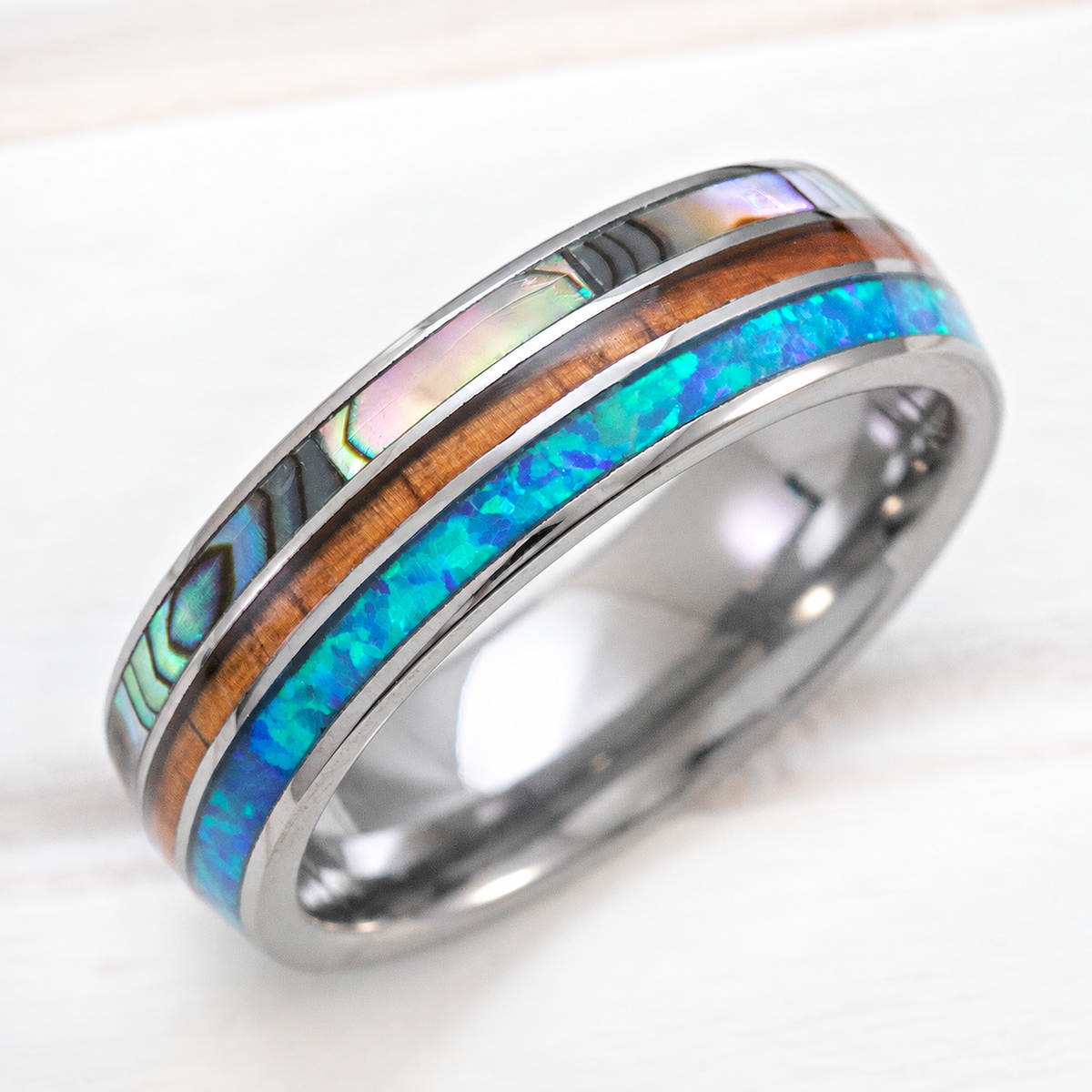 Tungsten carbide ring with abalone shell, koa wood, and blue opal tri-inlay
