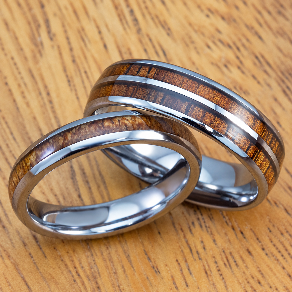 Pair of polished tungsten rings with Hawaiian koa wood inlays