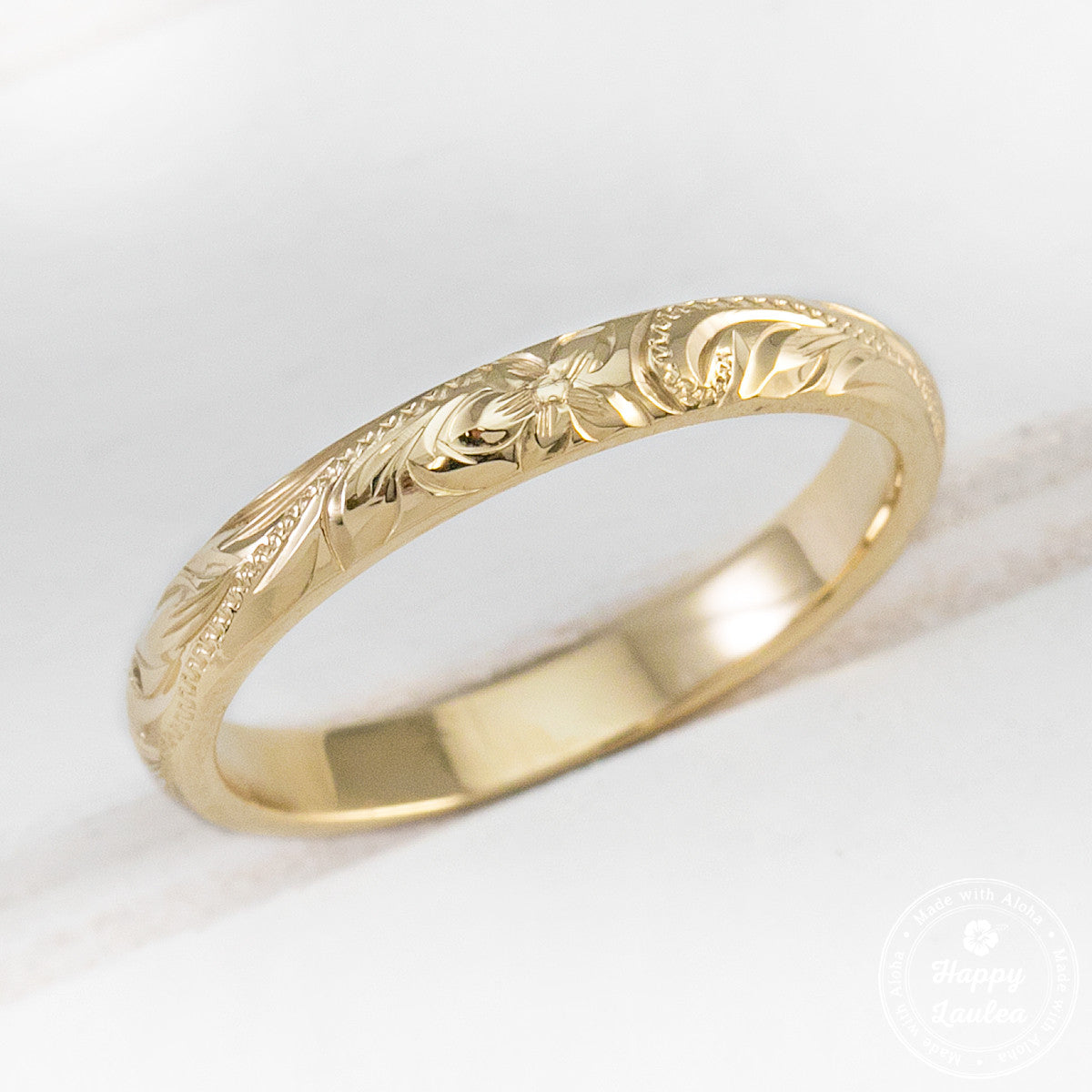 Side view of a 2.5mm yellow gold Hawaiian Old English hand engraved band