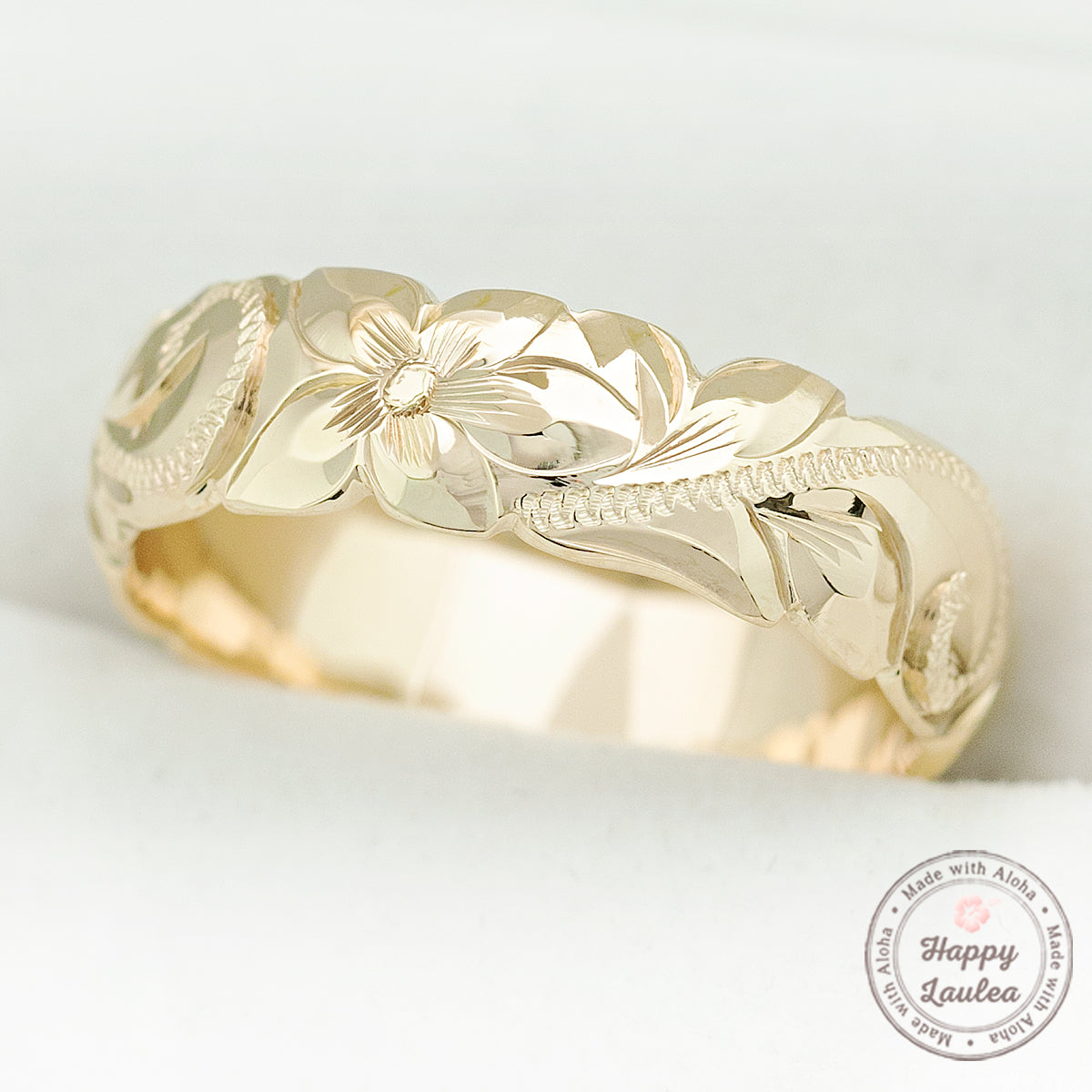 Yellow gold 6mm Hawaiian band hand engraved with plumeria and scroll detail