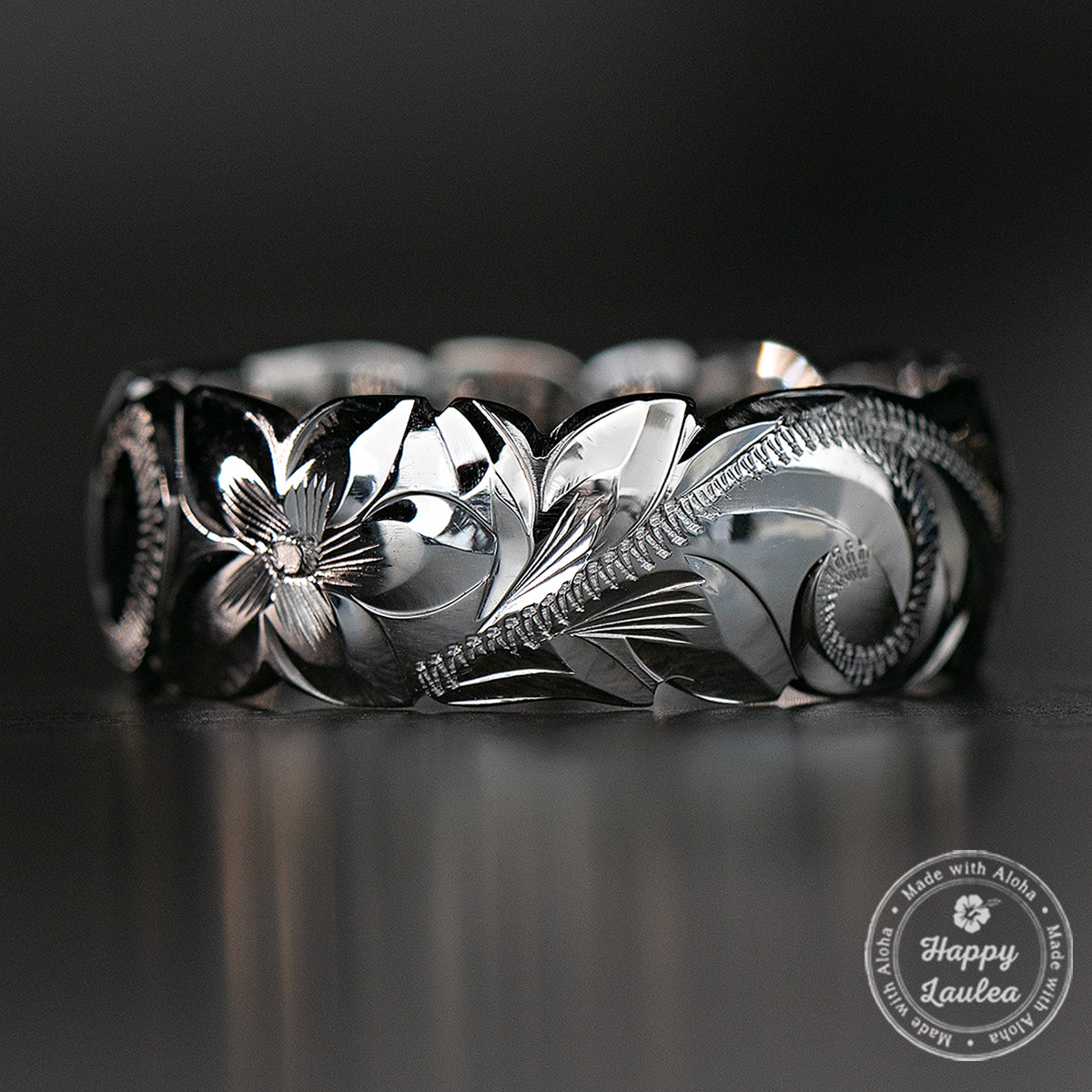 White gold 8mm Hawaiian ring hand engraved with plumeria and scrollwork, wave cut edges