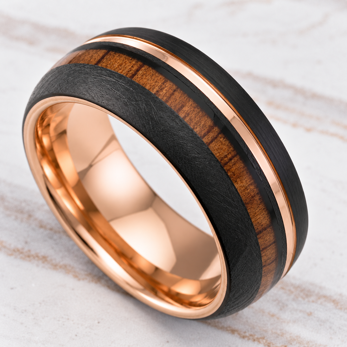 Black tungsten ring with offset rose gold stripe and Hawaiian koa wood inlay, alternate angle
