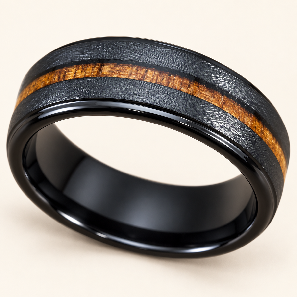 Low angled view of a black cross-brushed tungsten ring with a central koa stripe and dark comfort-fit interior