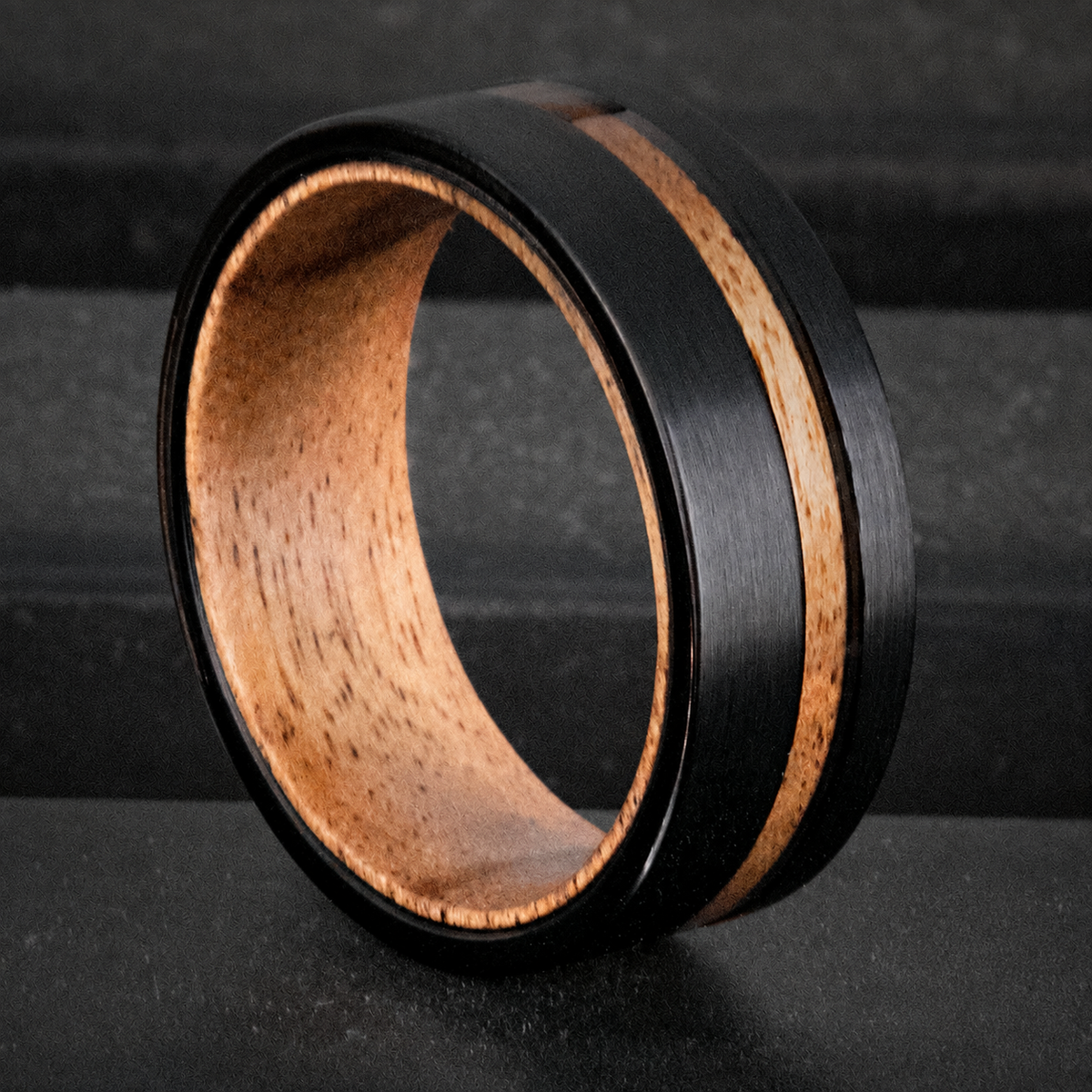 Black tungsten ring with offset koa wood inlay and koa wood sleeve