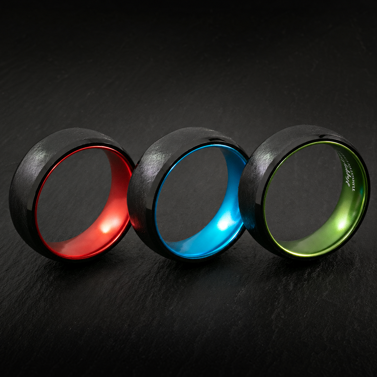 Black tungsten rings with red, blue, and green aluminum sleeves