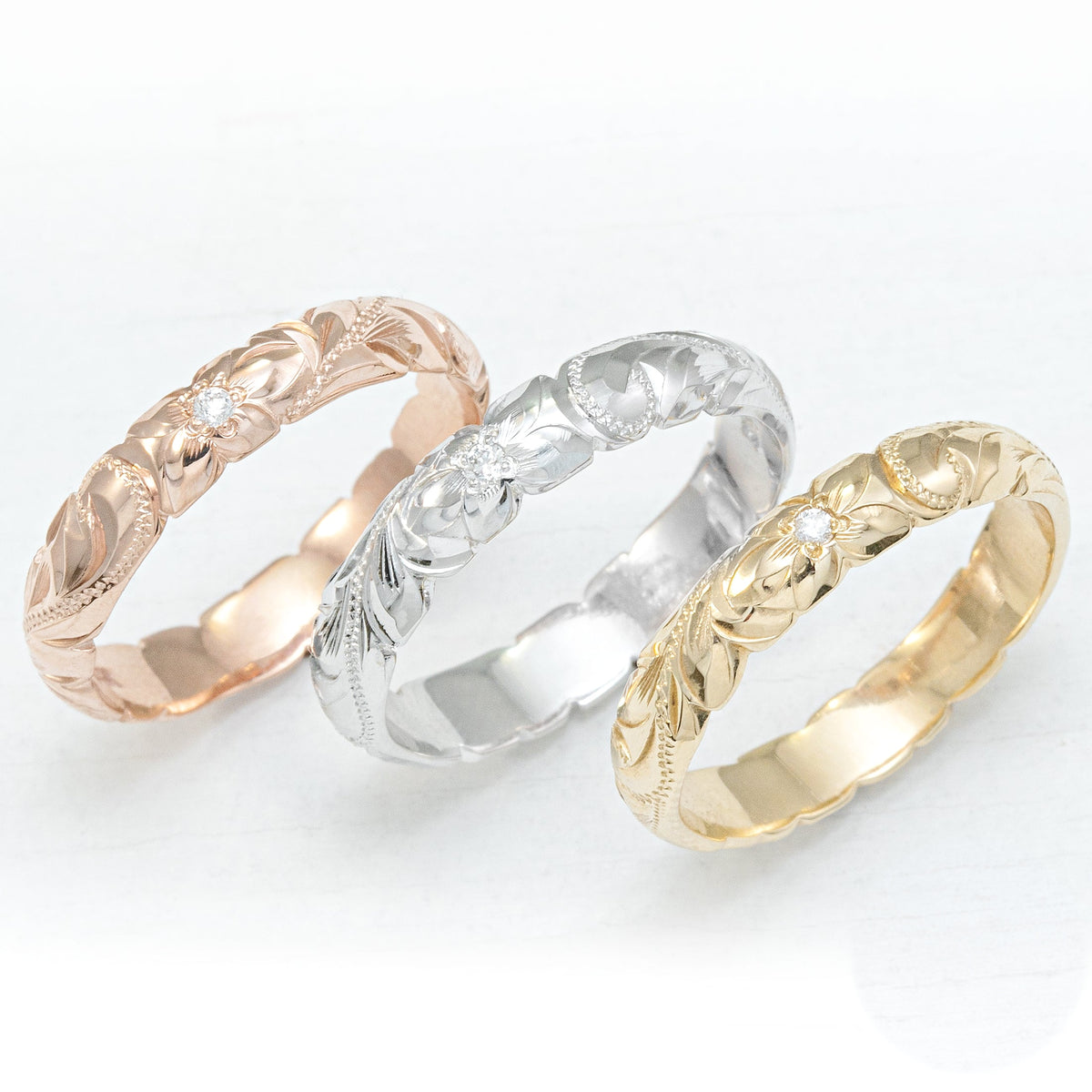 Three 4mm Hawaiian wave edge rings in rose, white and yellow gold, hand engraved