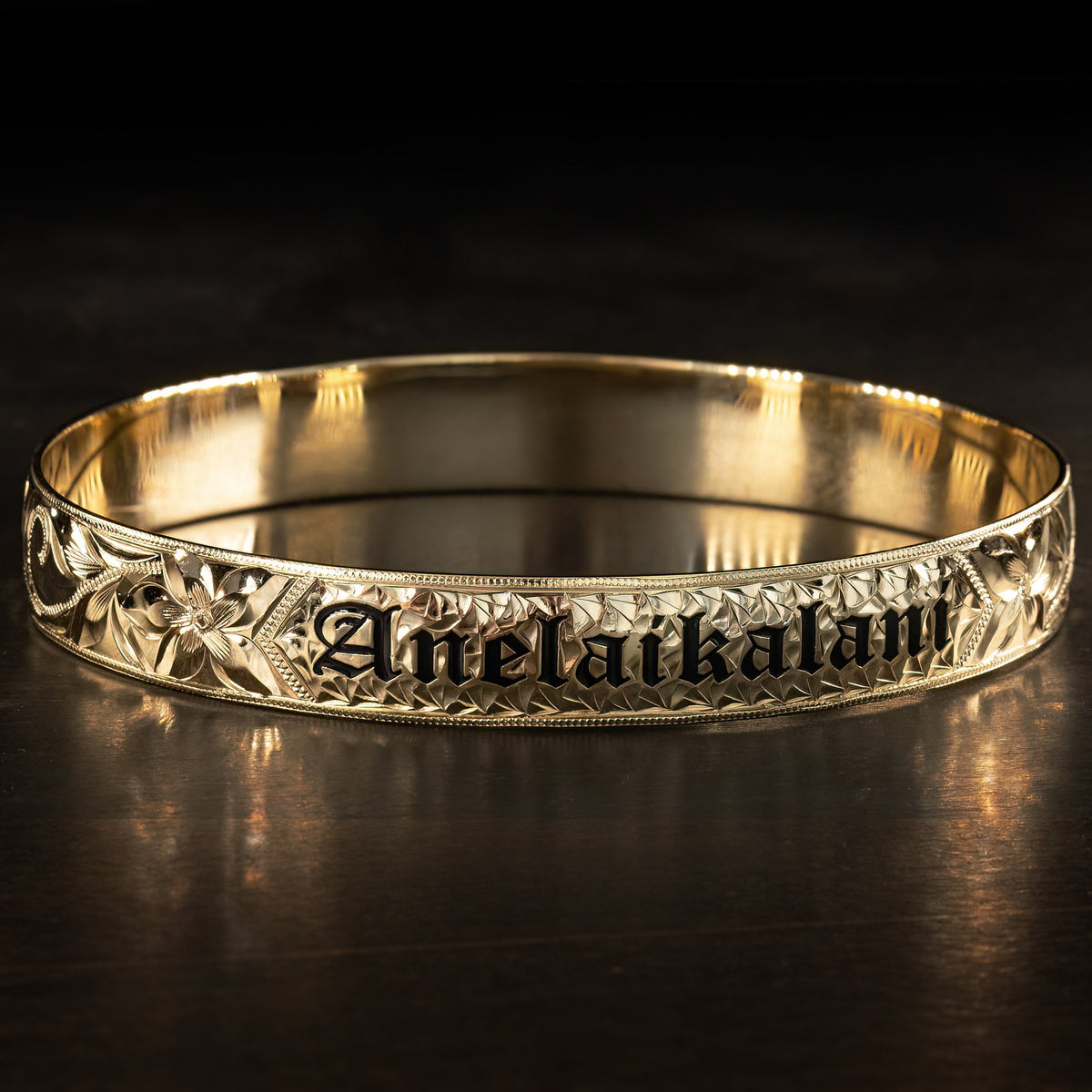14K gold Hawaiian name bracelet with black enamel lettering, 10mm width