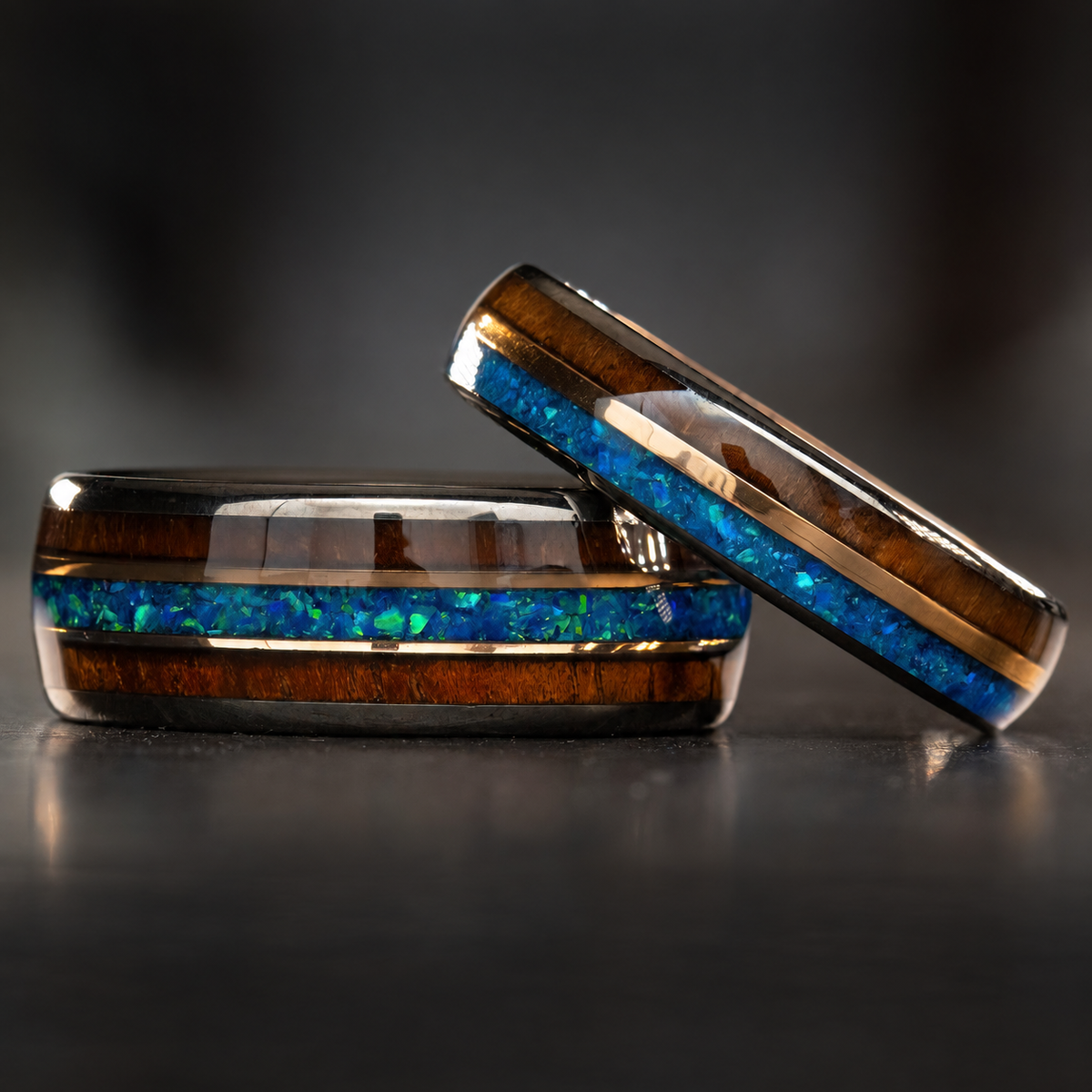 Gunmetal tungsten ring set with blue opal, Hawaiian koa wood, and rose-gold strips