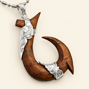 Hawaiian koa wood fishhook pendant with engraved sterling silver details and chain on ivory