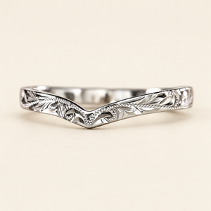 White gold chevron wishbone ring with Hawaiian leaf and scroll engraving, 3mm wide, on an ivory background.