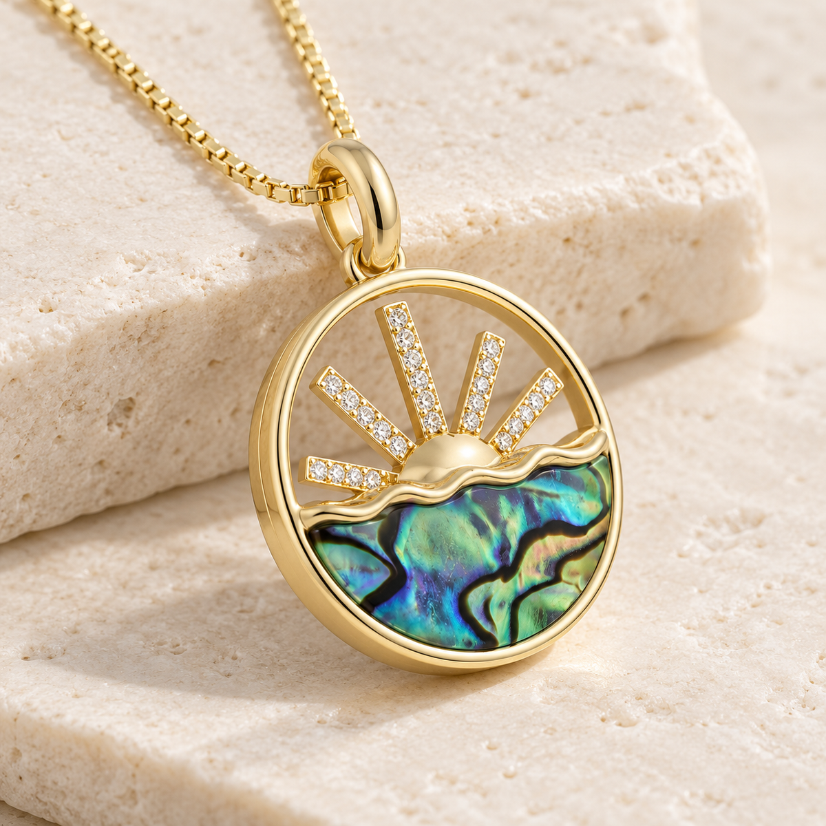 Angled view of 14K gold iridescent mother of pearl and diamond sunrise pendant