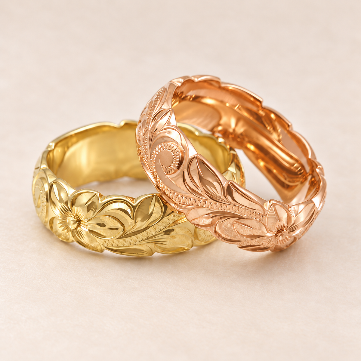 Yellow and rose gold 6mm Hawaiian rings with scalloped wave edges and floral scroll engraving on an ivory background.
