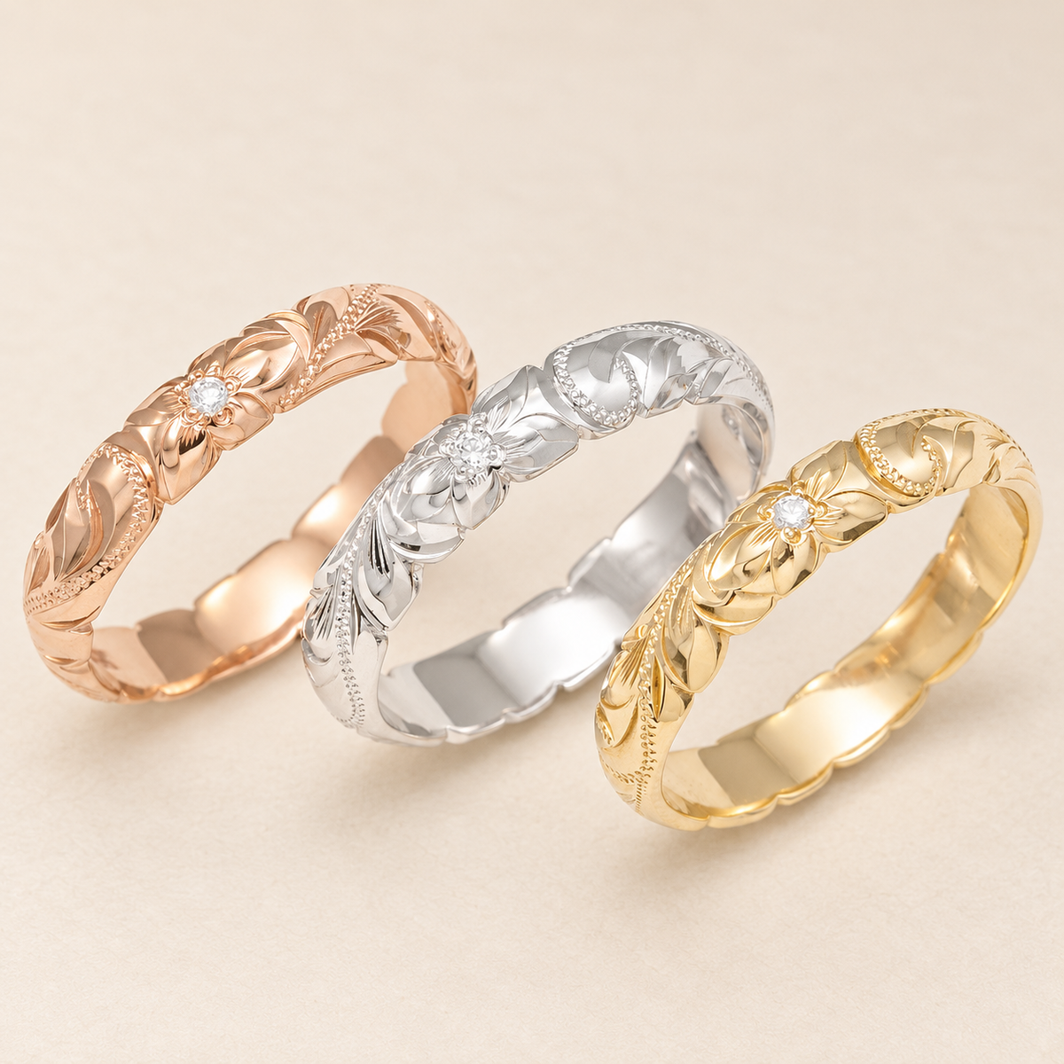 Three 4mm Hawaiian heritage wave-edge rings in rose, white and yellow gold on ivory.