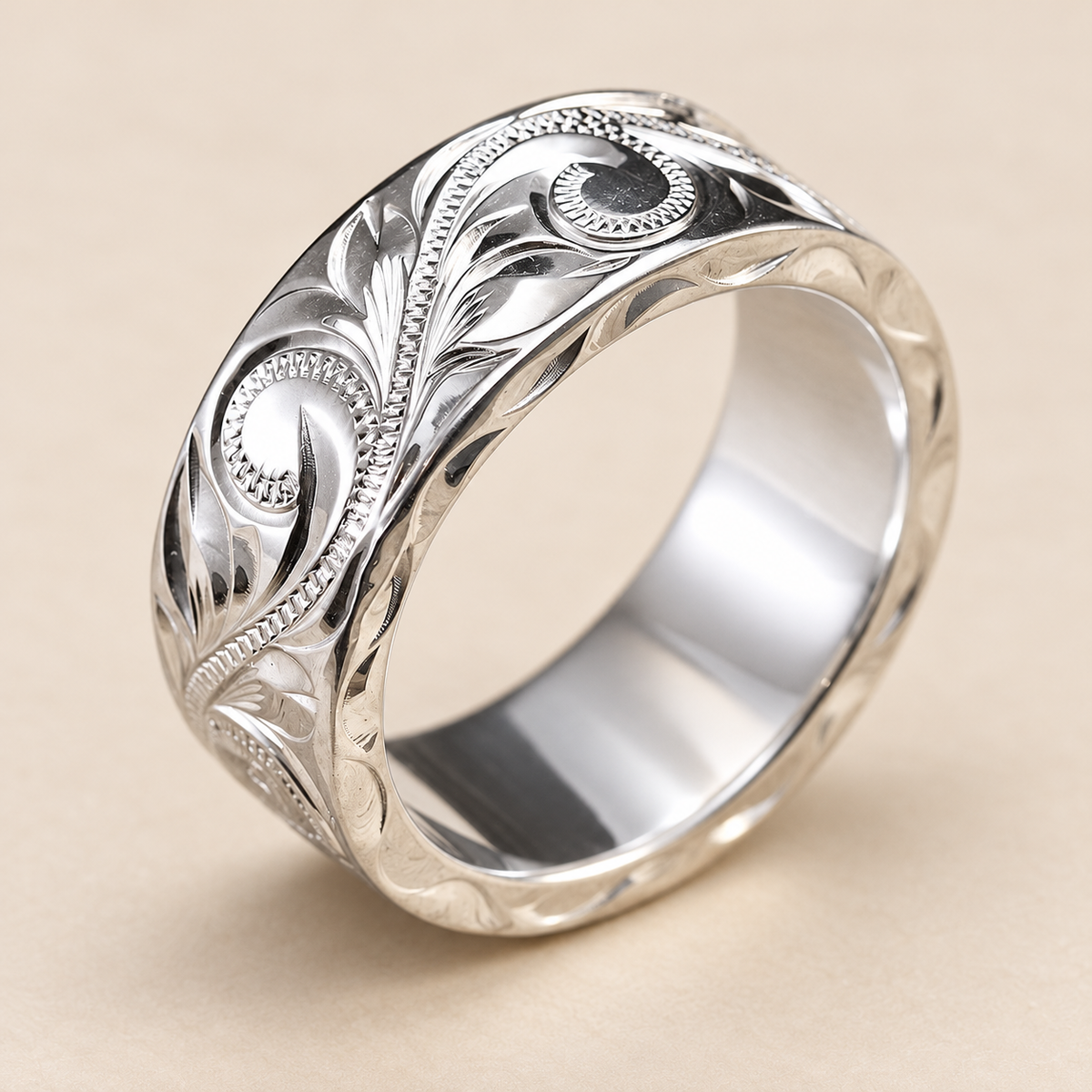 8mm wide, 2mm thick sterling silver Hawaiian hand-engraved flat ring with scroll and leaf details, open three-quarter view on an ivory background