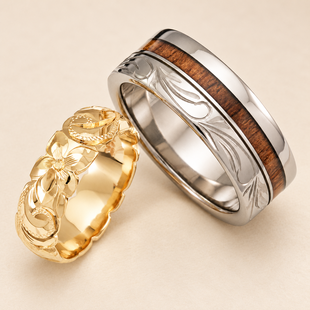 Yellow gold Hawaiian floral ring paired with a silver-tone titanium ring with koa wood inlay and scroll engraving on ivory.