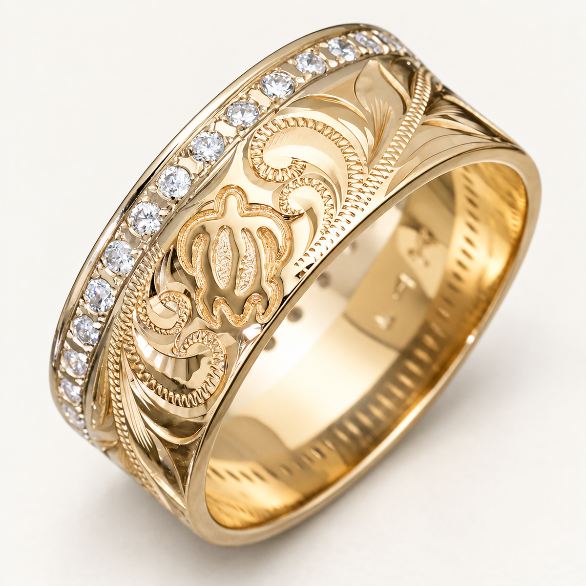 Yellow gold 9mm Hawaiian Honu infinity ring with hand engraving and a row of diamonds, photographed on ivory