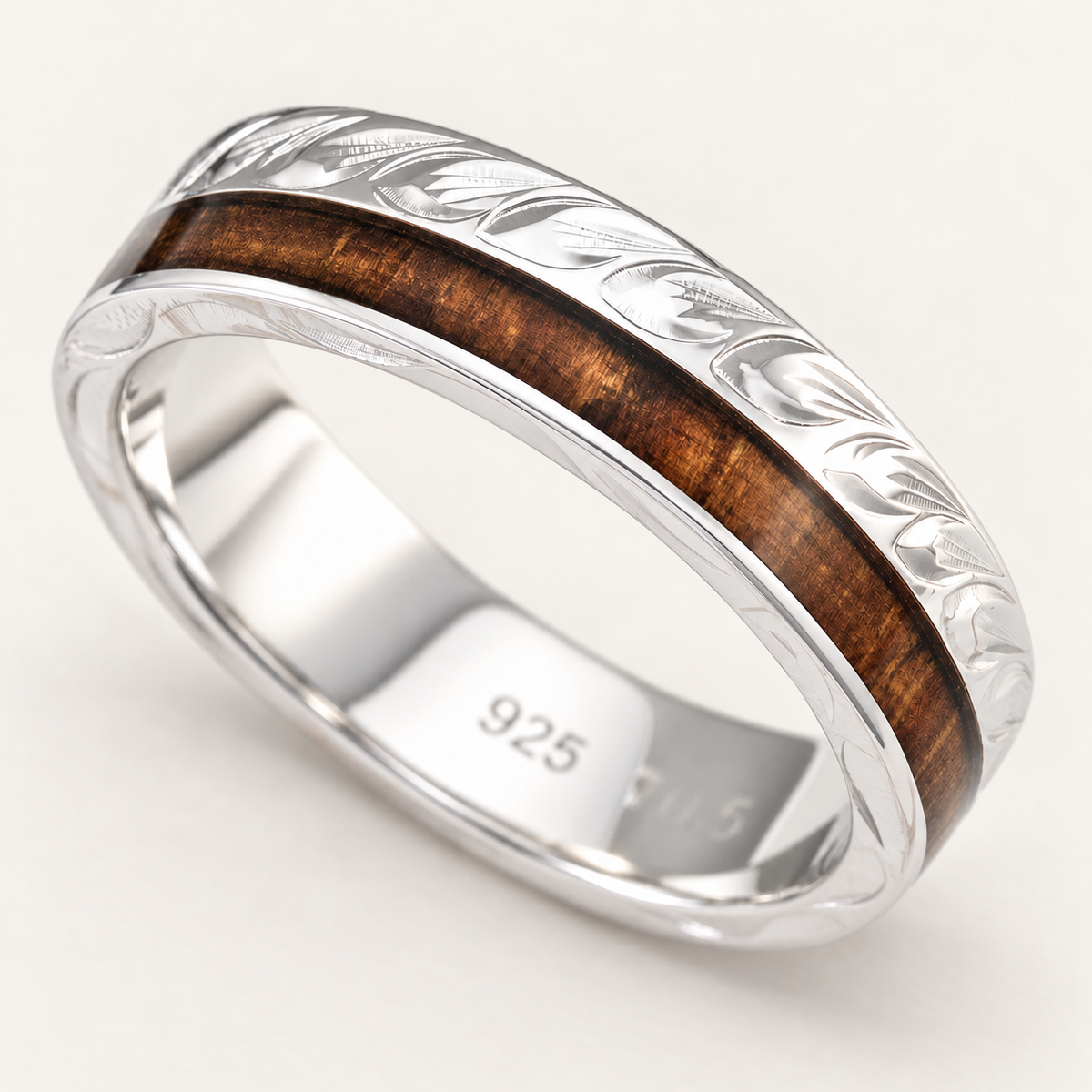 Sterling silver maile leaf ring with Hawaiian koa wood inlay, lower angled view showing the interior on an ivory background