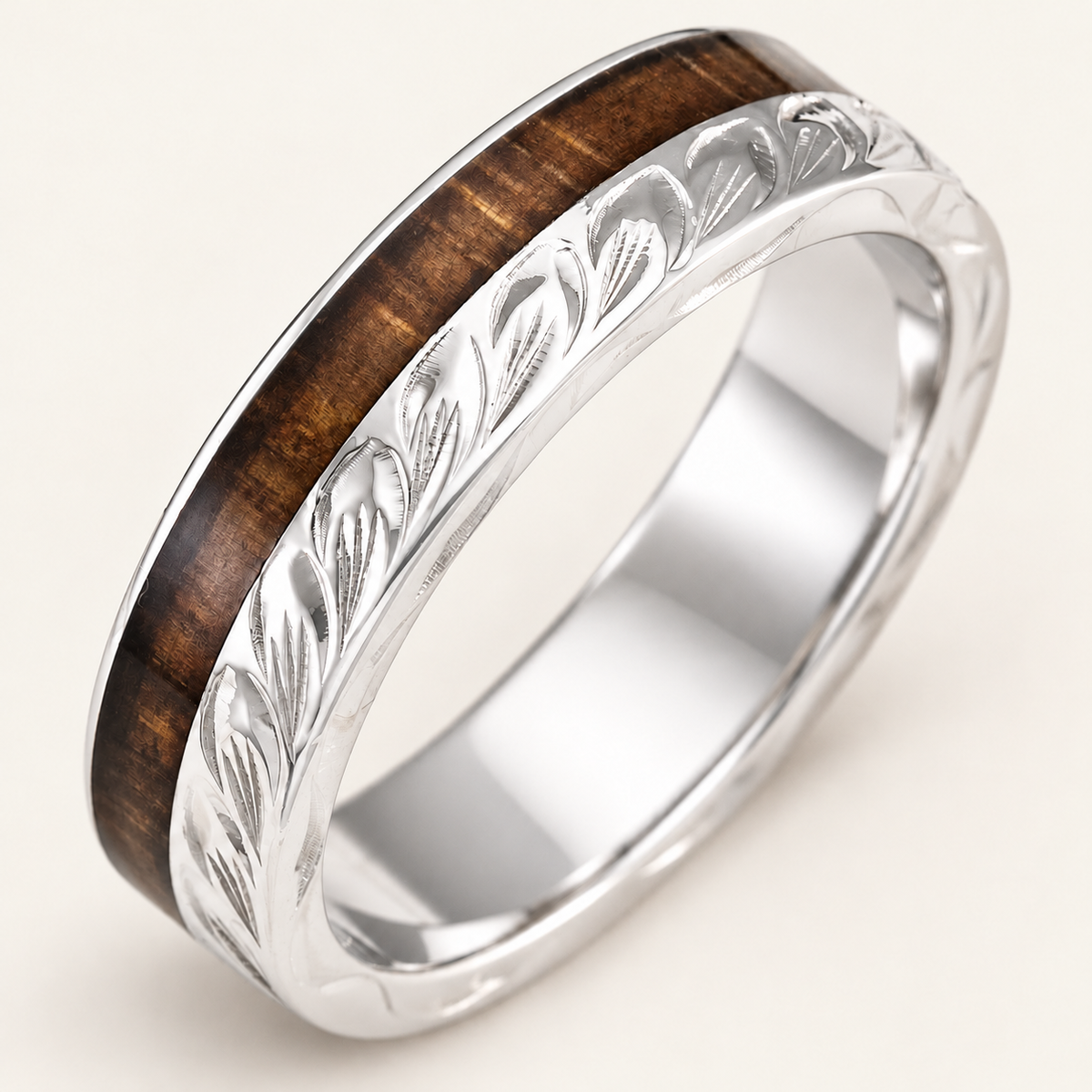 Sterling silver maile leaf ring with offset Hawaiian koa wood inlay, upright diagonal view on an ivory background